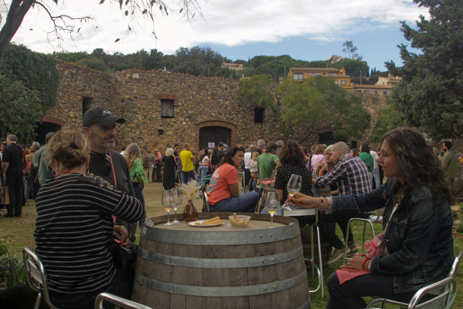 Visitants tastant vi i formatge al voltant d’una bóta durant la fira Contraban a Rabós d’Empordà