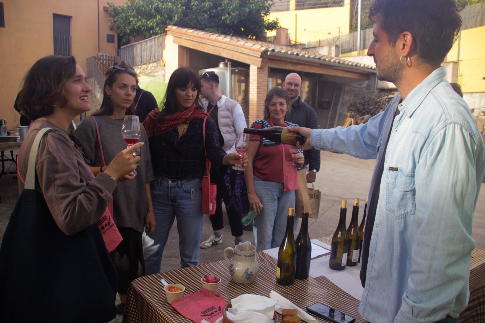 Visitants tastant vins en un pati del poble durant la cinquena edició de Contraban a Rabós d’Empordà